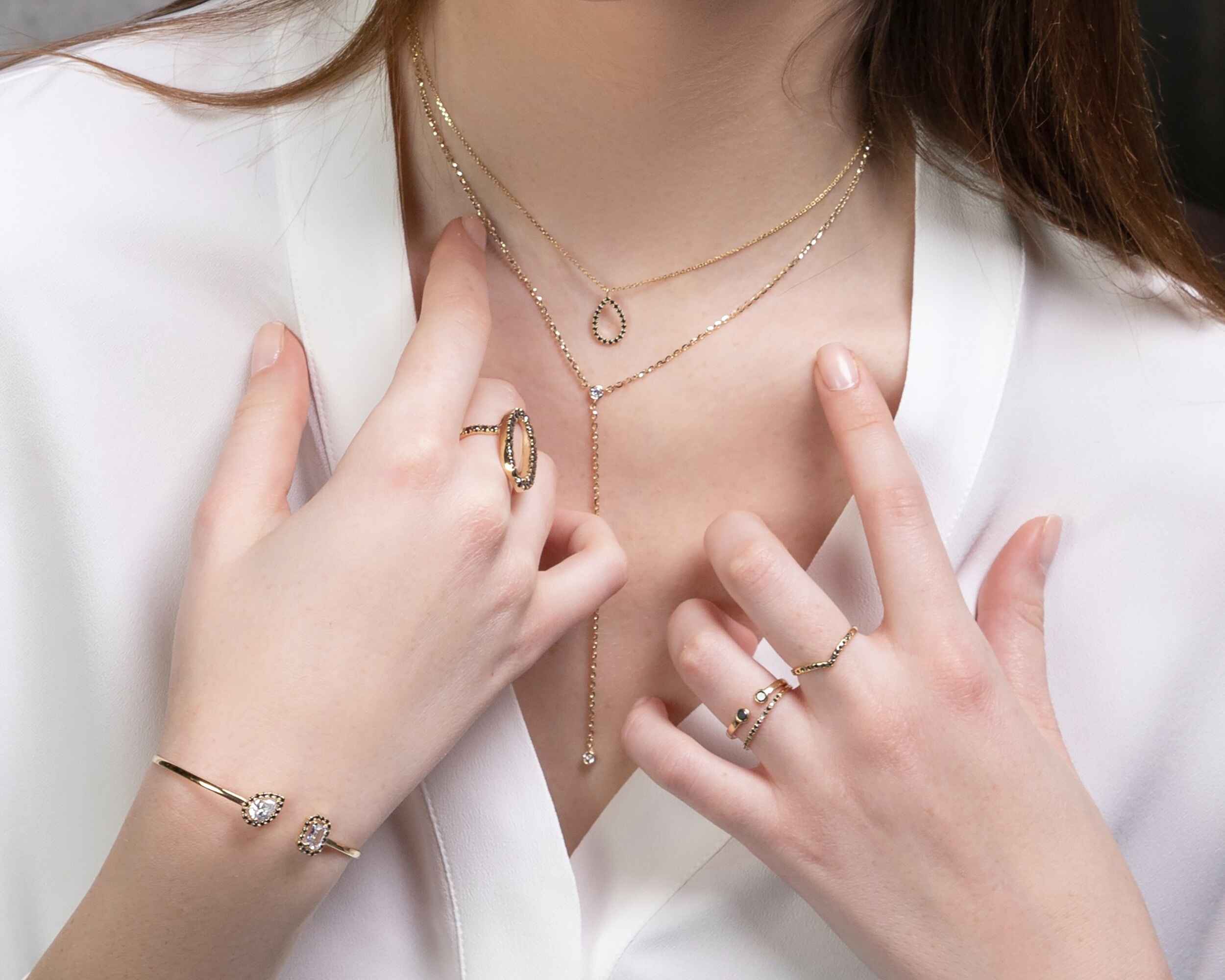 person wearing rings, necklaces, and a bracelet